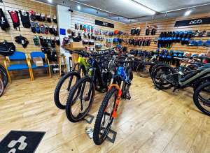 MPG Cycles shop in Dalbeattie featuring display electric mountain bikes, Cube signage, and customer parking area.